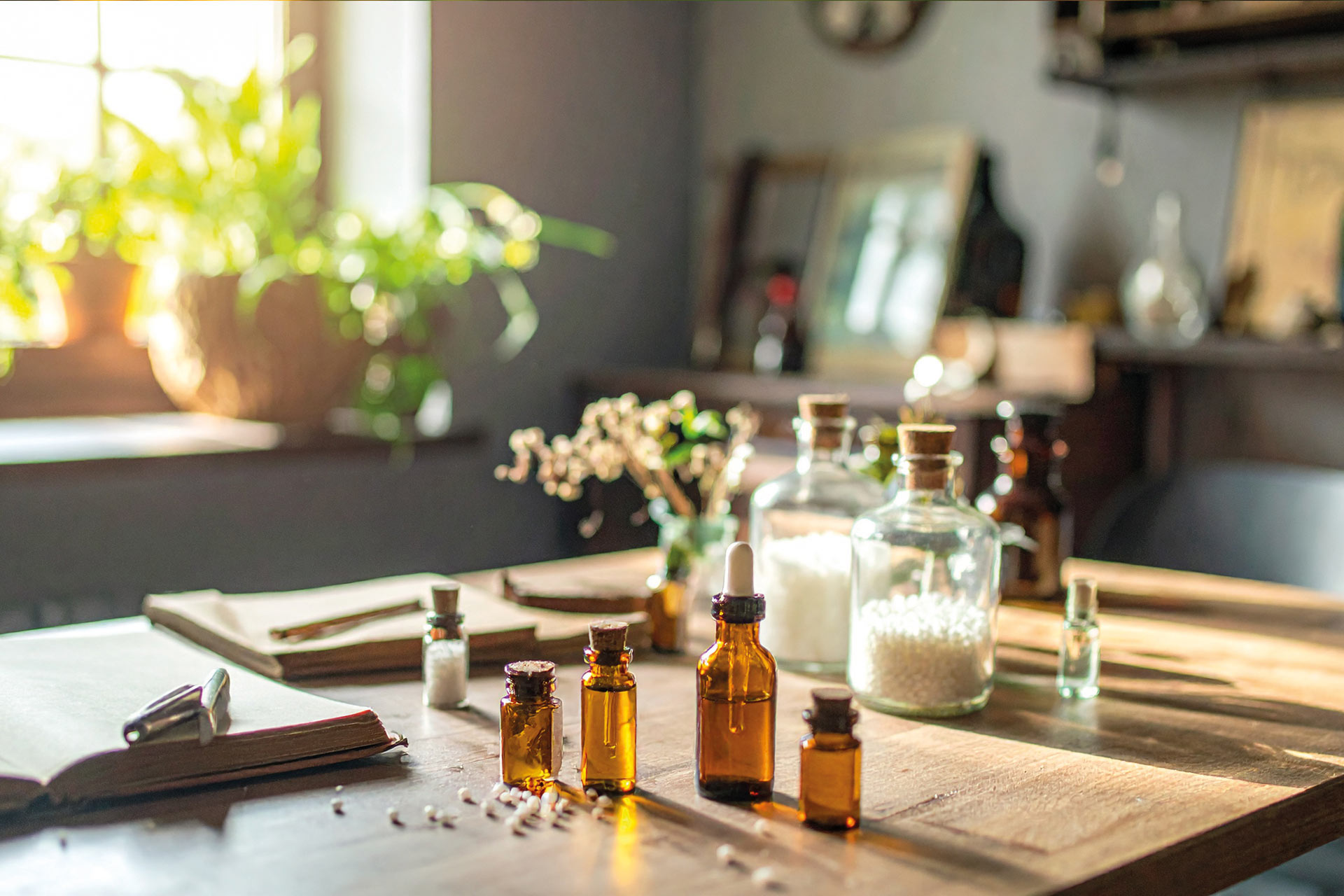 Homöopathische Globuli, Tinkturen und Naturheilmittel auf einem Holztisch in einer Naturheilpraxis